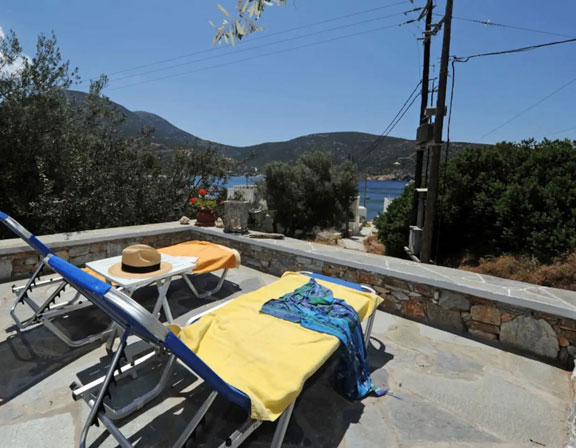 Cour pavée avec chaises longues à la Villa Vathy